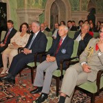 Nj.K.V. Princeza Katarina, Nj.K.V. Prestolonaslednik Aleksandar II, zamenik vojnog atašea SAD Robert Mejn i francuski vojni ataše Ruanet Olivije prate izlaganje predavača na okruglom stolu „Kralj Aleksandar I Ujedinitelj i njegovo vreme“ u bioskopskoj sali Kraljevskog Dvora