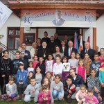Crown Prince Alexander, Crown Princess Katherine and His Grace Bishop Lavrentije of Sabac with the children in the yard of the Church in Koceljeva