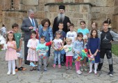 HRH Crown Prince Alexander, HRH Crown Princess Katherine and His Grace Bishop Teodosije of Ras and Prizren with children in front of Gracanica Monastery
